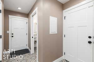 Foyer entrance with electric panel, recessed lighting, and light tile patterned floors