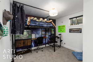 Bedroom featuring light carpet and a desk