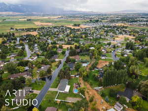 Aerial view of property and surrounding area with nearby suburban area and a mountain backdrop