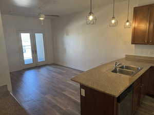 Kitchen featuring french doors, ceiling fan, stainless steel dishwasher, dark wood-style floors, and pendant lighting