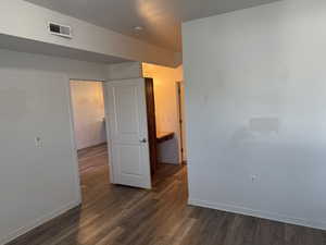 Unfurnished bedroom with dark wood-type flooring and a textured ceiling