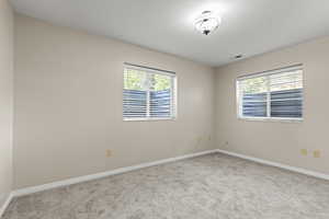 Guest Suite Bedroom with bright windows and new carpet and paint.