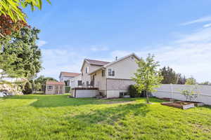 View of yard featuring a storage shed, a garden, and a wooden deck
