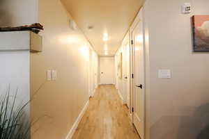 Hall with light wood-style floors and baseboards
