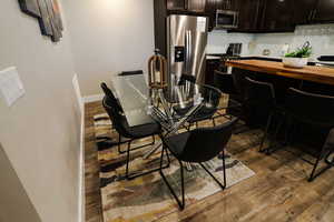 Dining space with dark wood-style flooring and baseboards