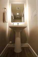 Bathroom featuring dark wood-style flooring and baseboards
