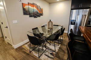 Dining room with dark wood finished floors and recessed lighting