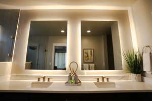 Full bathroom featuring a shower stall, double vanity, and recessed lighting