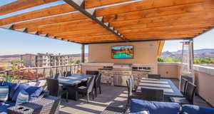 View of patio / terrace with outdoor dining area, a mountain view, and area for grilling