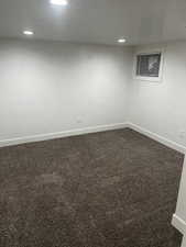 Spare room with dark colored carpet and recessed lighting