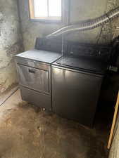 Laundry room with unfinished concrete floors and washing machine and dryer
