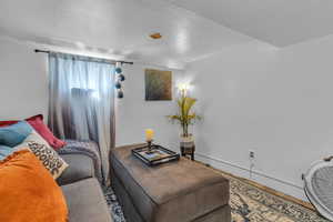 Bedroom with a textured ceiling and baseboard heating