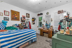 Bedroom with light carpet and baseboards