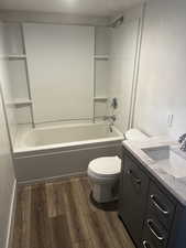 Bathroom featuring dark wood-style flooring, vanity, and bathtub / shower combination