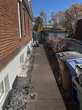 View of side of property with brick siding and a cooling unit
