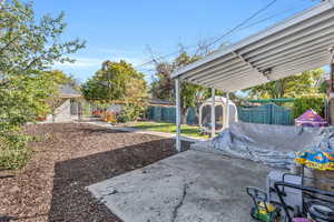 Fenced backyard featuring a shed and a patio