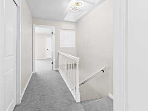 Hallway with an upstairs landing and carpet flooring