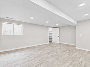 Below grade area featuring light wood-style flooring and recessed lighting
