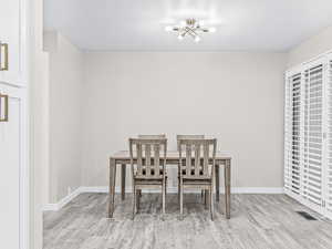 Dining room with light wood-style flooring and a chandelier