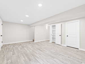 Finished below grade area featuring recessed lighting and light wood-style floors