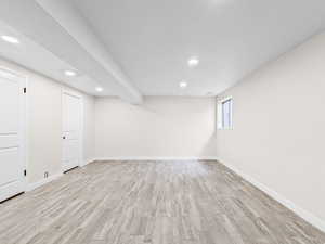 Basement with light wood-style floors and recessed lighting