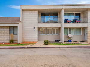 View of front of house with brick siding and a balcony