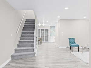 Staircase featuring wood finished floors and recessed lighting
