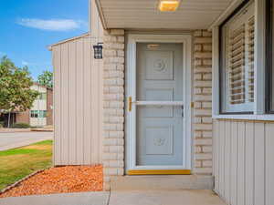 View of exterior entry featuring board and batten siding, stone siding, and brick siding