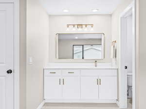 Full bath with vanity, light wood-style floors, and recessed lighting