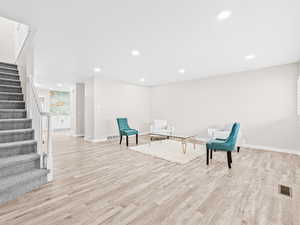 Living area featuring stairs, recessed lighting, and light wood finished floors