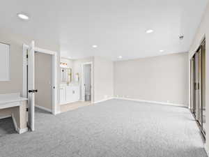 Unfurnished bedroom featuring a closet, recessed lighting, light colored carpet, and ensuite bathroom