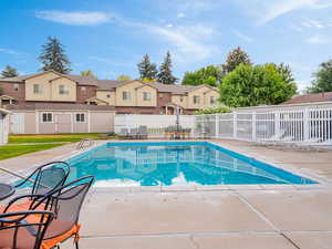 Community pool featuring a patio area and a residential view