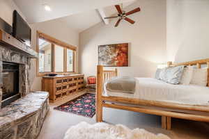 Bedroom 2 featuring a stone fireplace, ceiling fan and AC, mountain views