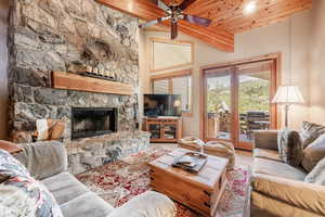 Living room featuring wooden ceiling, a fireplace, ceiling fan and AC, mountain views