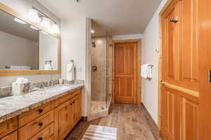 Full bath with vanity, a stall shower, and wood tiled floors, jetted tub
