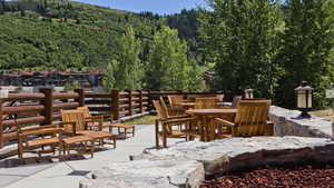 View of patio / terrace featuring outdoor dining space and a forest view with an out door fire pit