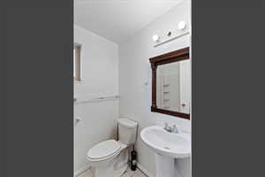 Half bath featuring light tile patterned floors and toilet