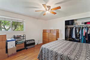 Bedroom with light wood finished floors, a closet, and a ceiling fan