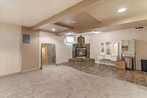 Living area featuring beamed ceiling, carpet floors, a fireplace, recessed lighting, and electric panel