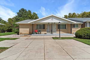View of front facade featuring a porch and brick siding