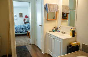 Full bath with vanity, dark wood-type flooring, and ensuite bathroom