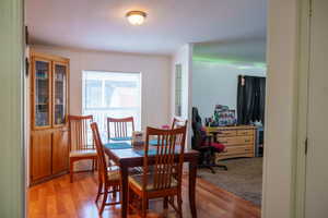 Dining space with a textured ceiling and light wood finished floors
