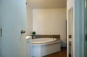 Full bathroom with a bath, vanity, dark wood-style flooring, crown molding, and a textured ceiling