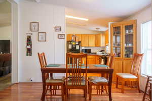 Dining space featuring light wood-style floors and lofted ceiling