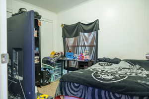Bedroom with a textured ceiling, crown molding, and carpet floors