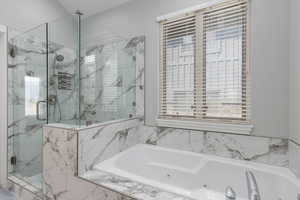 Bathroom with a marble finish shower and a whirlpool tub