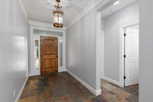 Foyer featuring stone tile floors and ornamental molding
