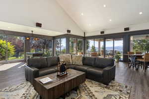 Living room featuring high vaulted ceiling, a mountain view, recessed lighting, wood finished floors, and plenty of natural light