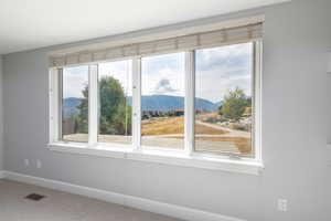 Unfurnished room featuring a mountain view and carpet