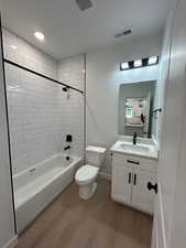 Full bathroom featuring vanity, light wood finished floors, shower / tub combination, and recessed lighting